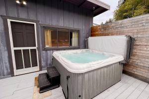 a hot tub sitting on a deck next to a building at Riverfront Escape in Monte Rio