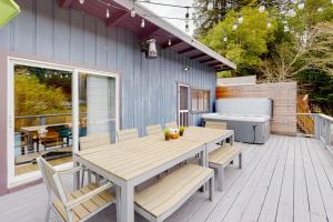 a wooden deck with a table and chairs on a house at Riverfront Escape in Monte Rio +18 photos