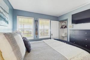 a bedroom with a bed with blue walls and windows at Coastal Dream in Bodega Bay