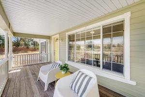a porch with two white chairs and a table at Bird and Barrel Vineyard Farmhouse in Healdsburg