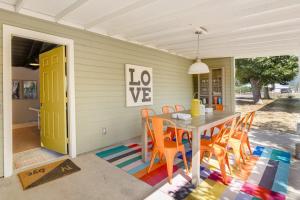 a table and chairs on a porch with a yellow door at Bird and Barrel Vineyard Farmhouse in Healdsburg