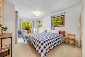 a bedroom with a bed and a desk and windows at Caz Cabin 6 in Cazadero