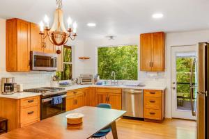 a large kitchen with wooden cabinets and a table at Caz Cabin 6 in Cazadero +31 photos