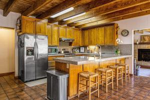 a kitchen with wooden cabinets and a stainless steel refrigerator at Sunrise Mountain Retreat in Cazadero