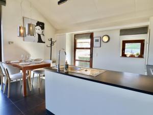 a kitchen with a sink and a table with chairs at Le Chemin des Framboises in Malmedy