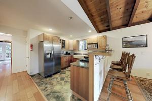 eine Küche mit Edelstahlkühlschrank und Holzschränken in der Unterkunft Wagging Woods in Cazadero