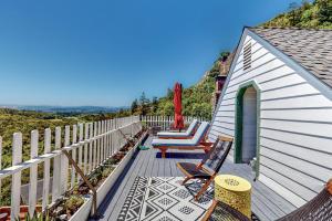 a house with a deck with chairs and a fence at Dragon Cottage in Healdsburg