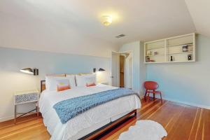 a bedroom with a large bed and a red chair at Dragon Cottage in Healdsburg