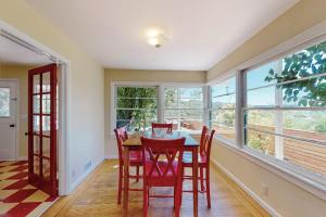 a dining room with a table and chairs and windows at Rooster Cottage in Healdsburg +15 photos