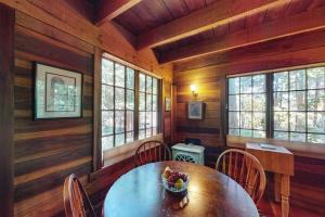 a dining room with a table and chairs and windows at Dreamcatcher Cottage in Cazadero