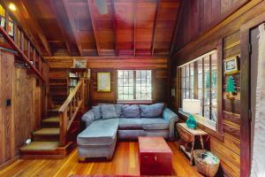 a living room with a couch and a staircase at Dreamcatcher Cottage in Cazadero
