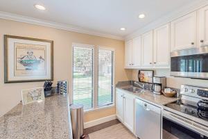 a kitchen with white cabinets and a large window at Silverado Resort and Spa 381 in Napa