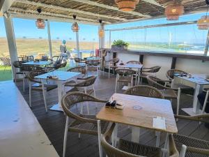 a restaurant with tables and chairs and a window at 51 E-scape Home in Corralejo