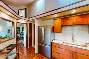 a kitchen with wooden cabinets and a stainless steel refrigerator at Monte Rio Vista Lodge in Monte Rio