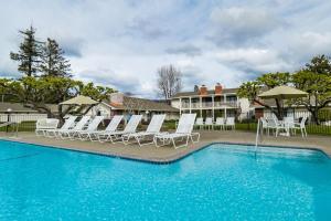 a pool with chairs and umbrellas in front of a house at Silverado Resort and Spa 221 in Napa