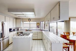 a large kitchen with white cabinets and a table at Sea Way Dreams in Bodega Bay