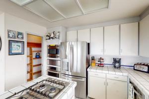 a kitchen with white cabinets and a stainless steel refrigerator at Sea Way Dreams in Bodega Bay +15 photos