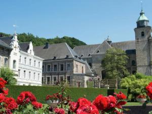 a large building with red flowers in front of it at Le Chemin des Framboises in Malmedy