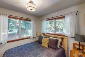 a bedroom with a bed and two windows at Cazadero Dreams in Cazadero