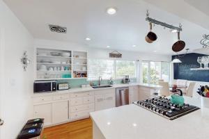 a kitchen with white cabinets and a stove top oven at Jewell Dreams in Santa Rosa