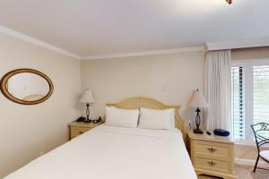 a white bedroom with a bed and a mirror at Silverado Resort and Spa 267 in Napa