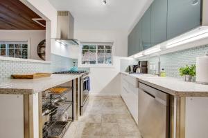 a large kitchen with white counters and appliances at Wanderlust Cottage in Guerneville +23 photos