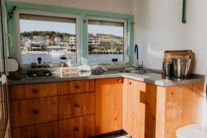 a kitchen with wooden cabinets and a large window at Zeleni Biser- Green Pearl in Lukavac