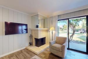 a living room with a fireplace and a chair and a television at Silverado Resort and Spa 353 in Napa