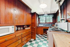 a kitchen with wooden cabinets and a white microwave at Clearheart Grove in Guerneville