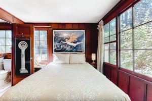 a bedroom with a bed in a room with windows at Clearheart Grove in Guerneville