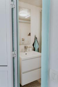 a white bathroom with a sink and a mirror at Zeleni Biser- Green Pearl in Lukavac