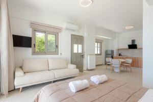 a white living room with a couch and a kitchen at Pelagia Apartments in Koroni