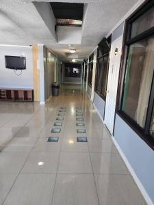 a hallway of a building with tiles on the floor at Hostal Tamarhugo in Calama