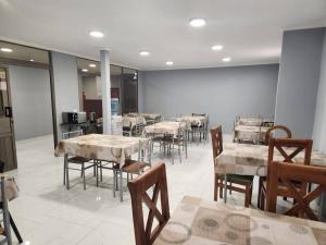 a dining room with tables and chairs in a room at Hostal Tamarhugo in Calama