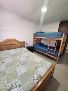 a bedroom with two bunk beds and a blue chair at Hostal Tamarhugo in Calama +24 photos