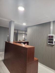 an office lobby with a reception desk and a wall at Hostal Tamarhugo in Calama