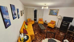 a living room with a yellow couch and chairs at Zona Sur, Bajo Seguencoma Flat in La Paz