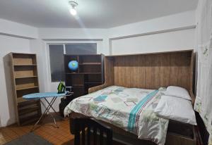 a bedroom with a bed and a table and a window at Zona Sur, Bajo Seguencoma Flat in La Paz