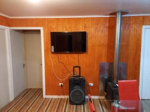 a room with a television on a wall with a table at cabañas los treiles in Cumpeu