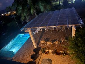 an overhead view of a pool with chairs and a solarium at Tekauhivai Lodge in Uturoa +32 photos