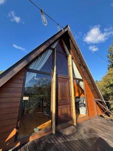 a small house with a large door on a deck at Chalé Recanto da Ema in Urubici
