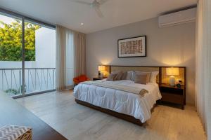 a bedroom with a large bed and a large window at Casa del Paseo Luxury Home in Centro Rooftop Bar & 2 Pools in Mérida +22 photos