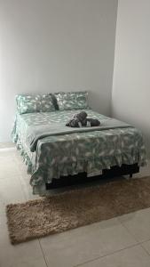 a bed with a dog laying on top of it at Casa de temporada Tarumã in Tangara da Serra