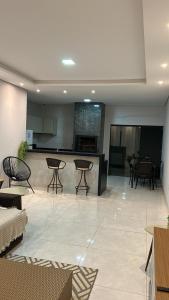 a living room with tables and chairs and a kitchen at Casa de temporada Tarumã in Tangara da Serra