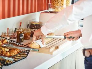 a baker preparing bread on a shelf in a kitchen at ibis budget Issoire in Issoire