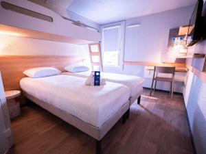 a hotel room with a bed and a small table at ibis budget Metz Sud in Augny