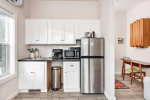 a kitchen with white cabinets and a stainless steel refrigerator at The Pinyon - Mountain View Retreat in Carbondale
