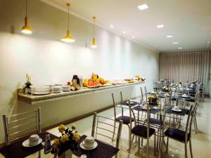 a dining room with tables and chairs and a buffet at Hotel Caetité in Caetité