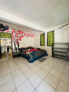 a bedroom with a bed and a tree mural on the wall at Pension Mitiana in Tatoi
