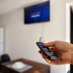 a person holding a remote control in their hand at Isabella's Cottage in Cholula